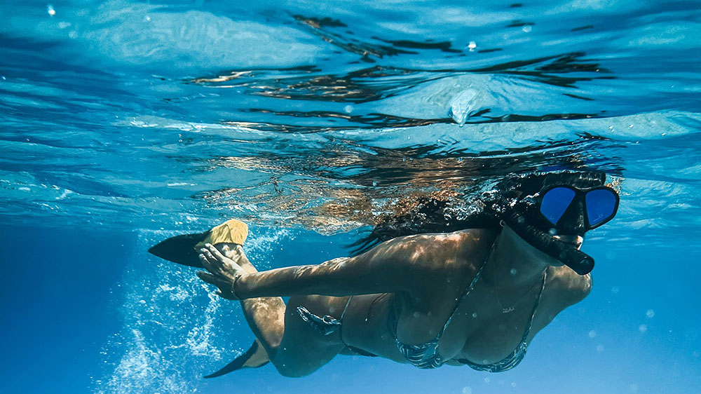 Jeune femme pratiquant le snorkeling